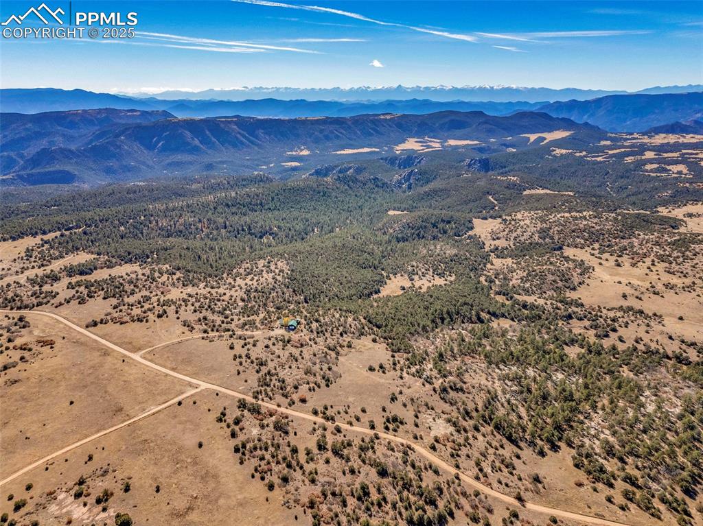 Image 47 of 50: Drone / aerial view of a mountain backdrop and a desert landscape