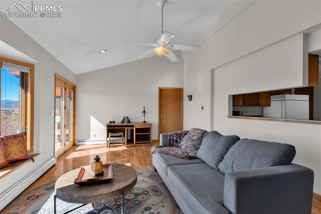 Image 8 of 50: Living room featuring a baseboard heating unit, light wood-style flooring, 