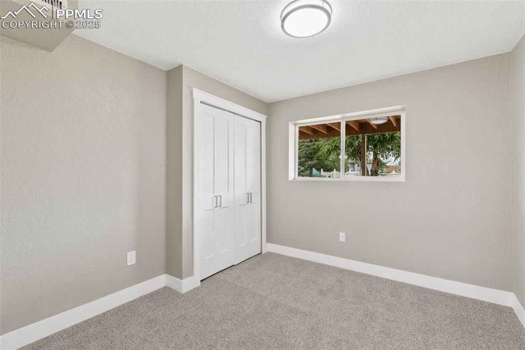 Image 12 of 18: Unfurnished bedroom with carpet flooring and a closet