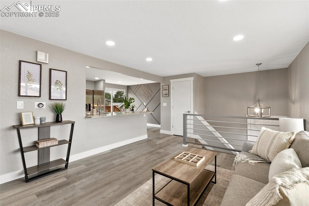 Image 4 of 18: Living area with wood finished floors and recessed lighting
