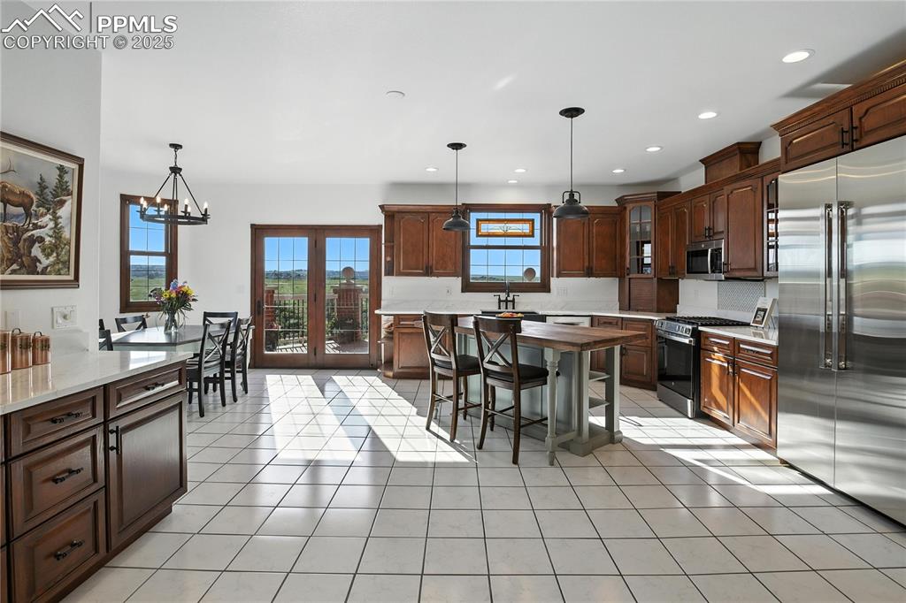 Image 12 of 50: Kitchen with appliances with stainless steel finishes, a chandelier, light