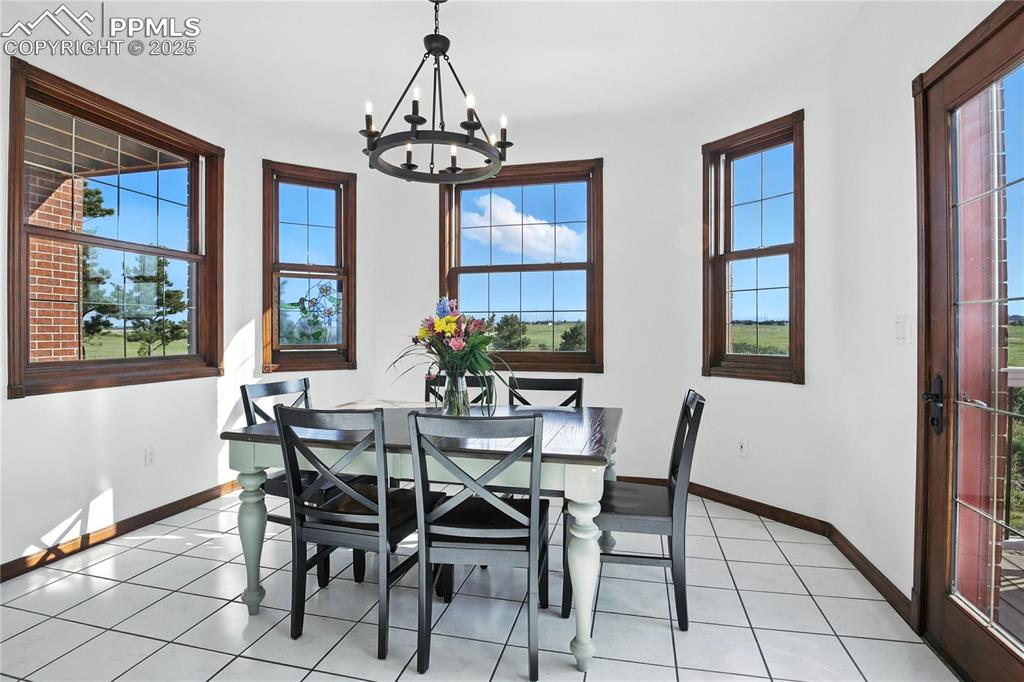 Image 16 of 50: Dining area featuring a chandelier and healthy amount of natural light
