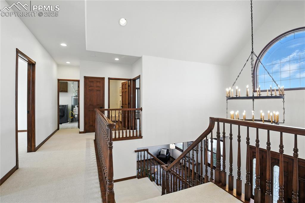 Image 24 of 50: Stairway with a chandelier, recessed lighting, and carpet flooring