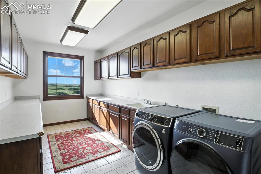 Image 27 of 50: Laundry area featuring separate washer and dryer, light tile patterned floo