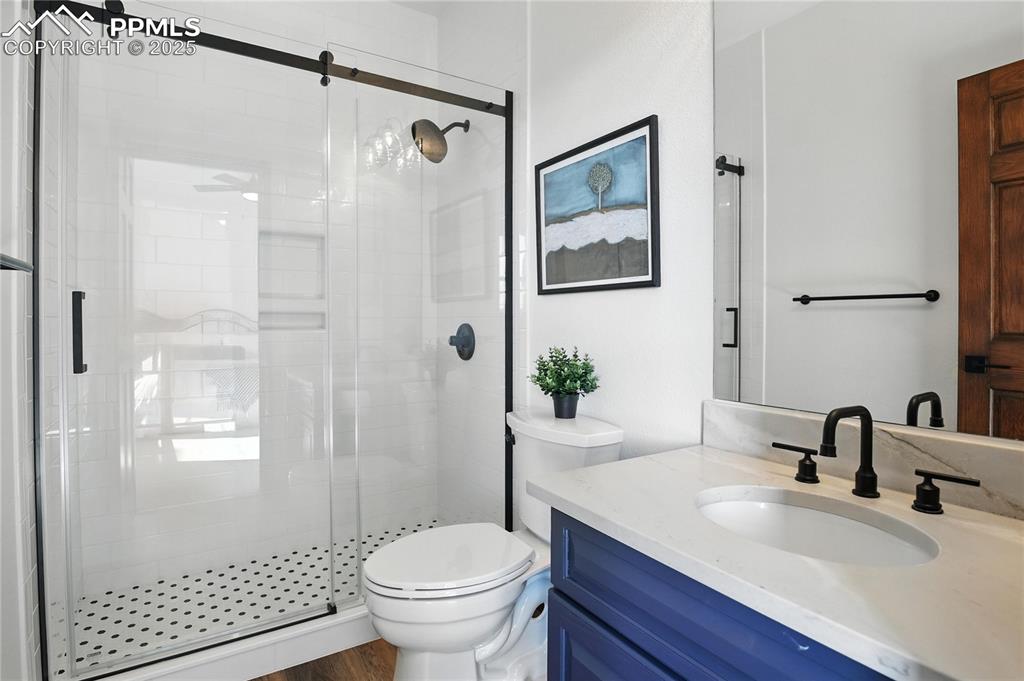 Image 34 of 50: Bathroom with a stall shower and vanity