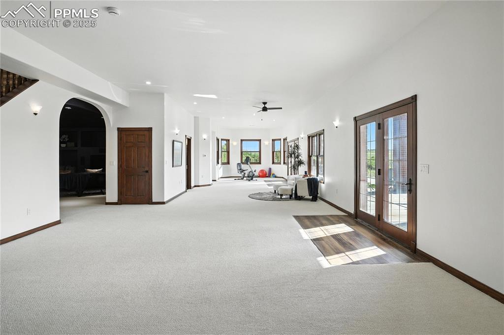 Image 36 of 50: Unfurnished living room featuring light carpet, arched walkways, a ceiling