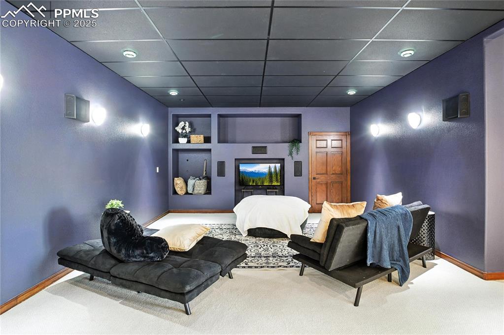 Image 40 of 50: Home theater room with a paneled ceiling, carpet floors, and built in featu