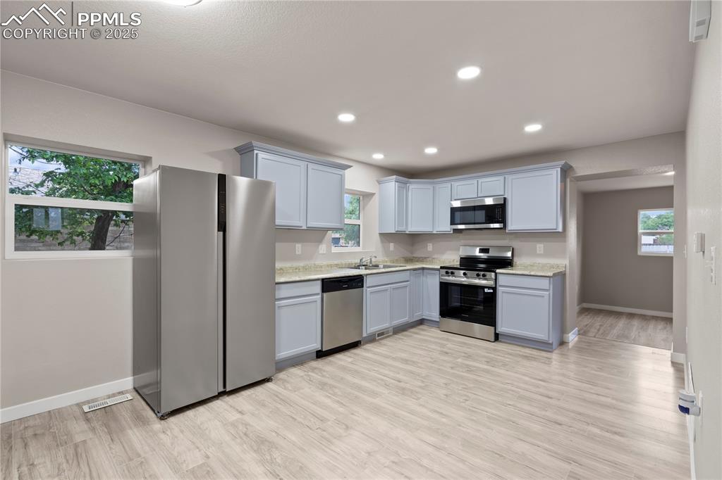 Image 10 of 26: Kitchen featuring stainless steel appliances, a sink, healthy amount of nat