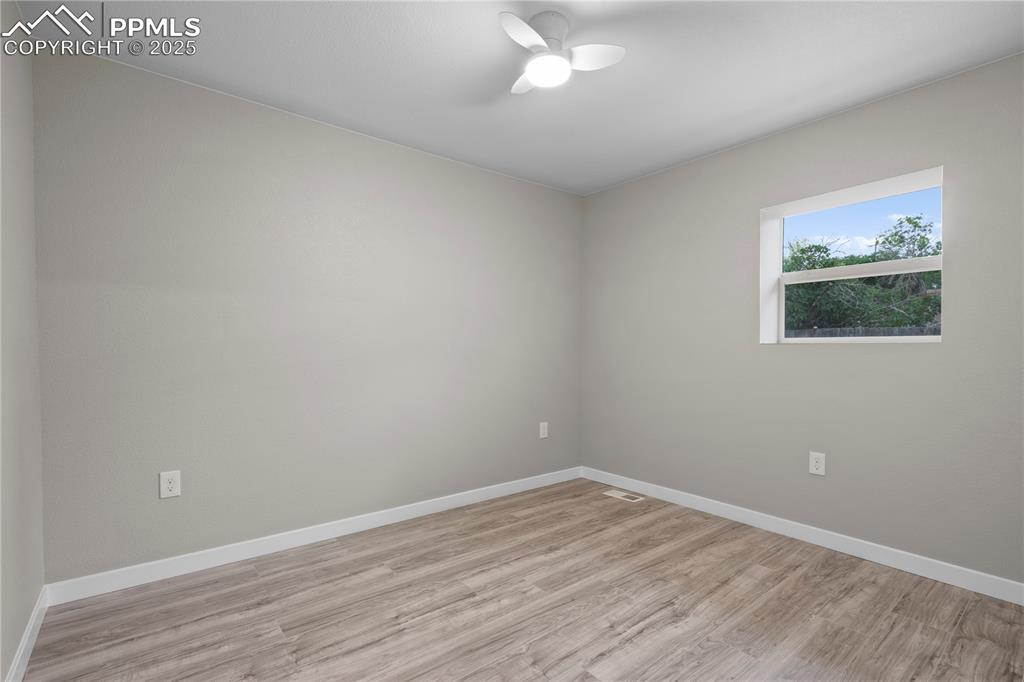 Image 20 of 26: Unfurnished room with light wood-type flooring, baseboards, and ceiling fan