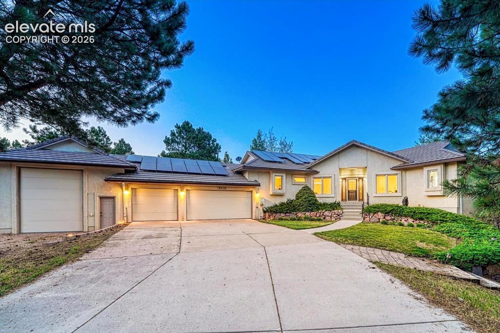 Caption: Sunset view of this beautifully maintained 5BR, 4BA ranch-style stucco home with a finished walk out