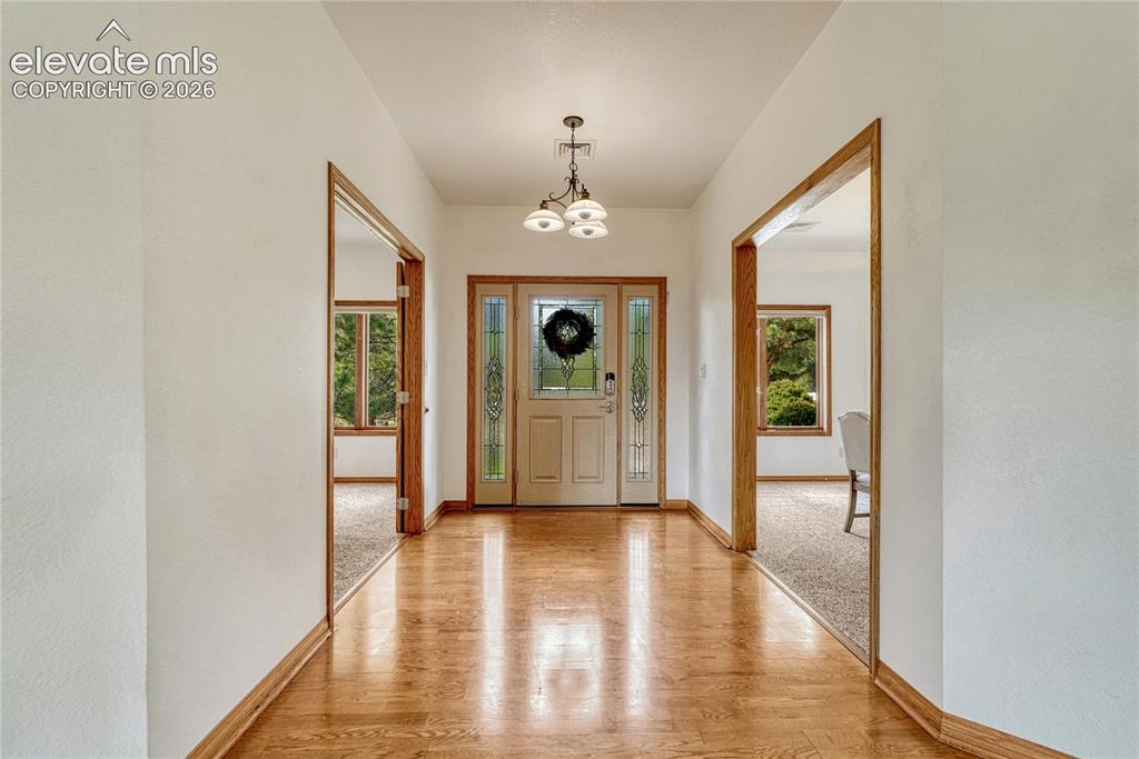 Image 13 of 50: Back inside: hardwood flooring continues through the entry, kitchen and gr