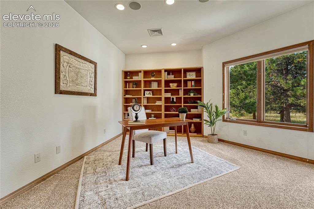 Image 14 of 50: Main level office off the entry with included shelving.