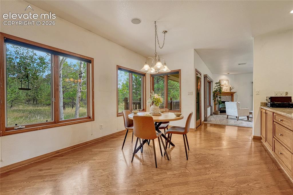 Image 22 of 50: Bright breakfast nook looks out to the trees, so private!