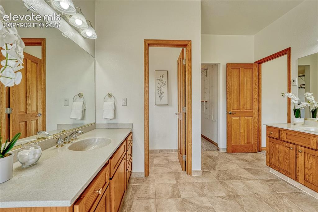 Image 28 of 50: Two separate vanities in the primary bath.