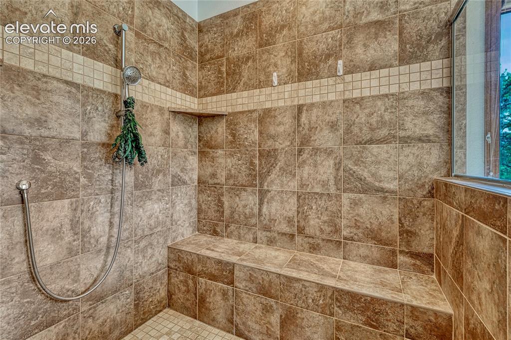 Image 29 of 50: Oversized tile shower with bench seat and a mud set tiled shower pan.