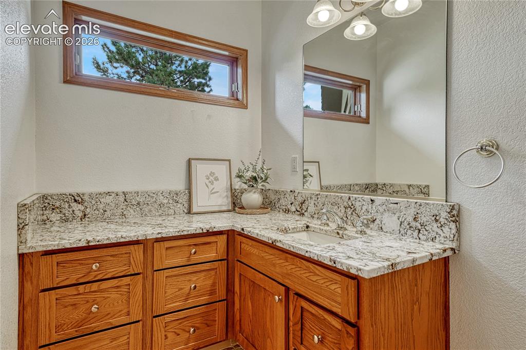 Image 33 of 50: Main level powder room with granite counter.