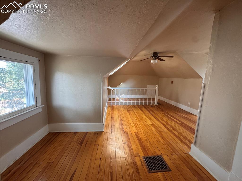 Image 16 of 16: Additional living space featuring a textured ceiling, light wood-style floo