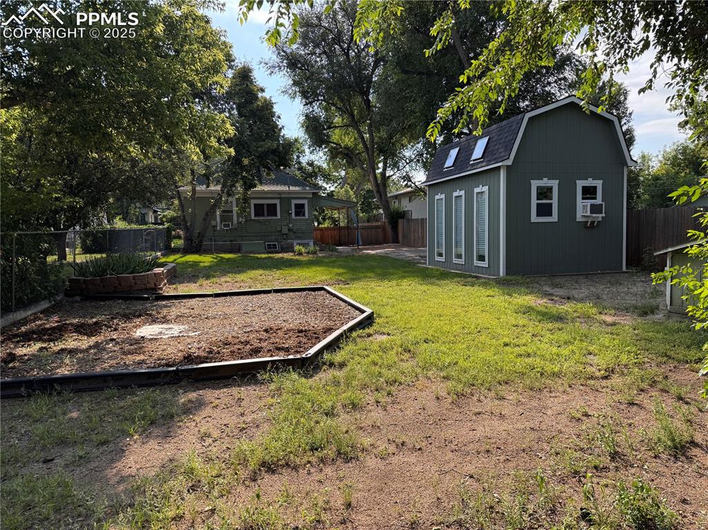 Image 3 of 16: Fenced backyard with play area, outdoor structure, and Garage