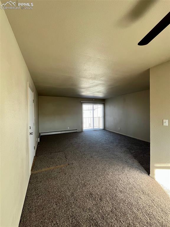 Image 12 of 26: View from dining room to living room, sliding glass door leads to balcony.