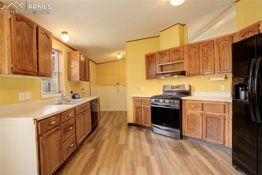 Image 13 of 43: Kitchen with mudroom/laundry beyond.
