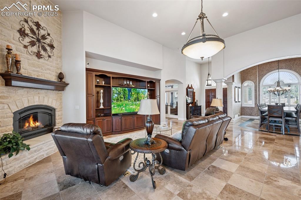 Image 10 of 48: Living area featuring arched walkways, decorative columns, a chandelier, a