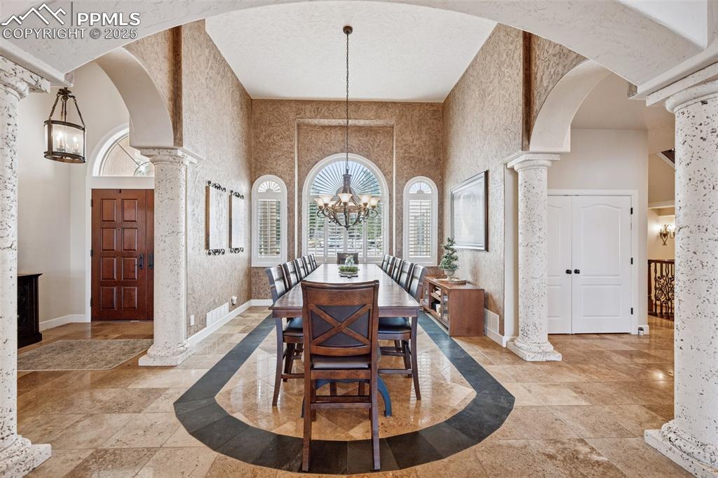 Image 11 of 48: Dining room featuring a chandelier, plenty of natural light, arched walkway