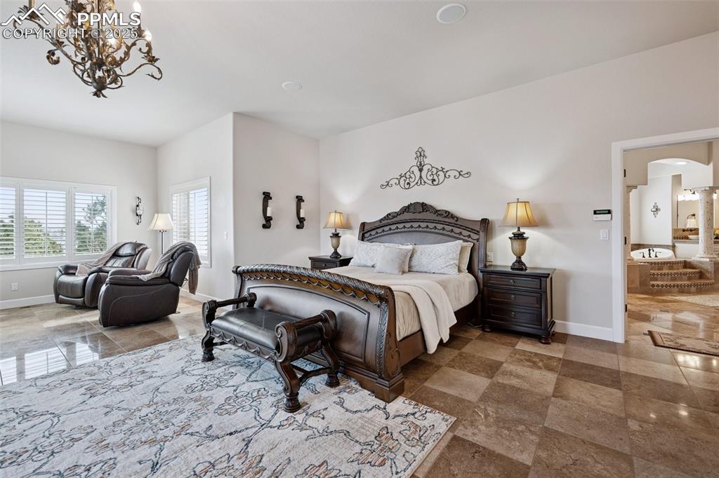 Image 21 of 48: Bedroom featuring arched walkways, baseboards, and a notable chandelier