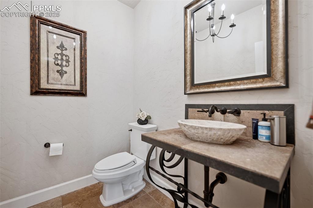 Image 25 of 48: Bathroom featuring a sink, decorative backsplash, baseboards, toilet, and t