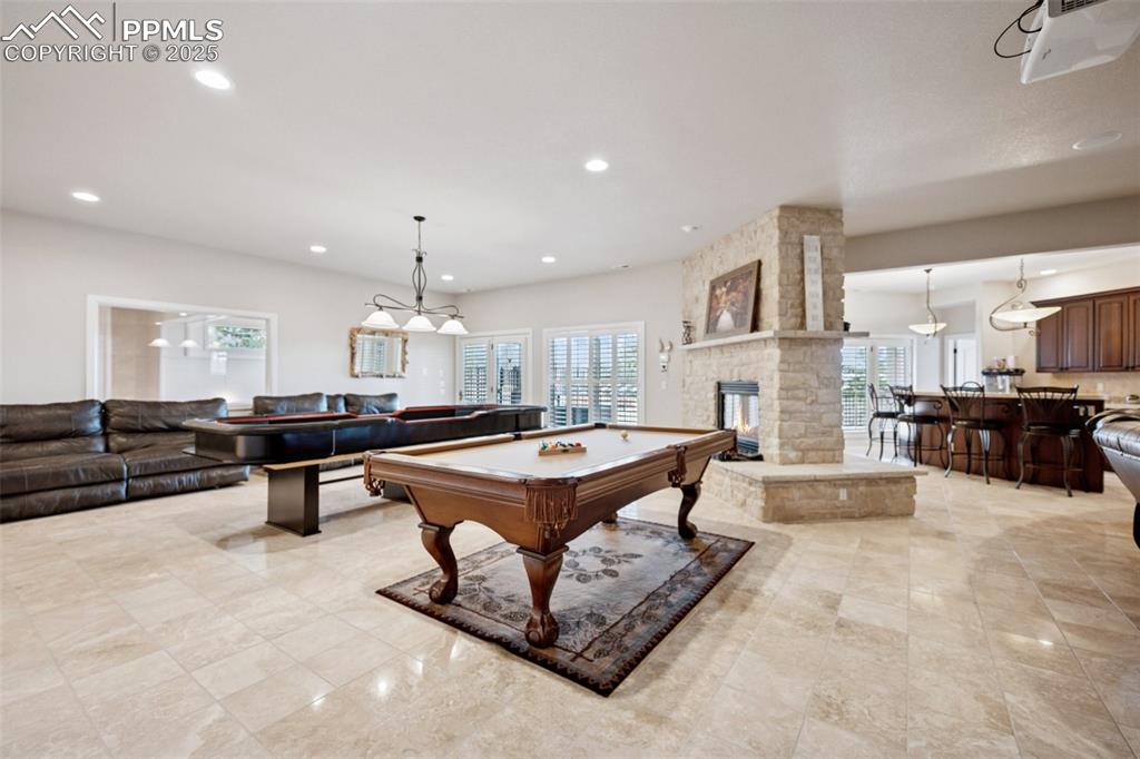 Image 34 of 48: Rec room featuring plenty of natural light, light tile patterned floors, an