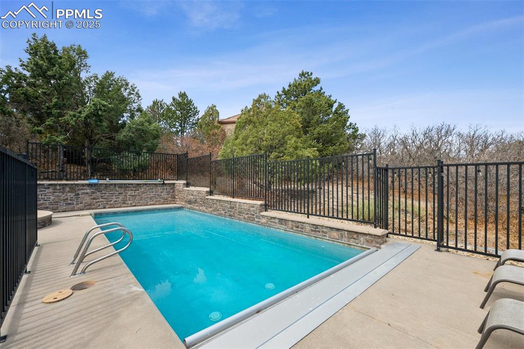 Image 45 of 48: View of pool featuring a fenced backyard, a fenced in pool, and a patio