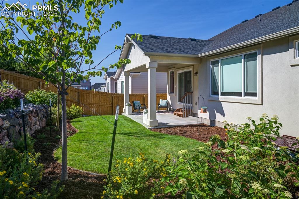 Image 4 of 44: Fenced backyard with a patio