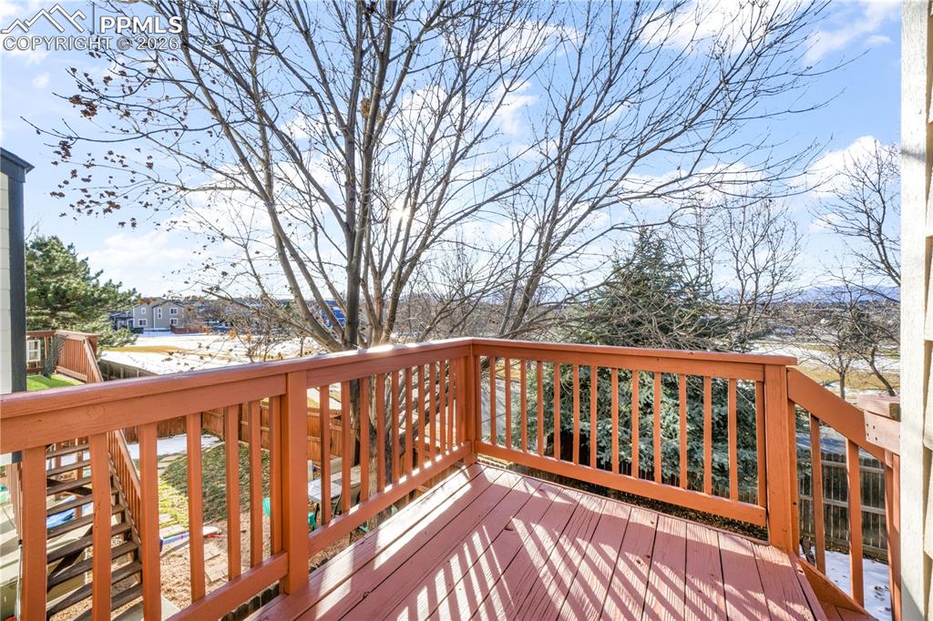 Image 13 of 50: Wood deck access from main level dining/living area with stairs to back yar
