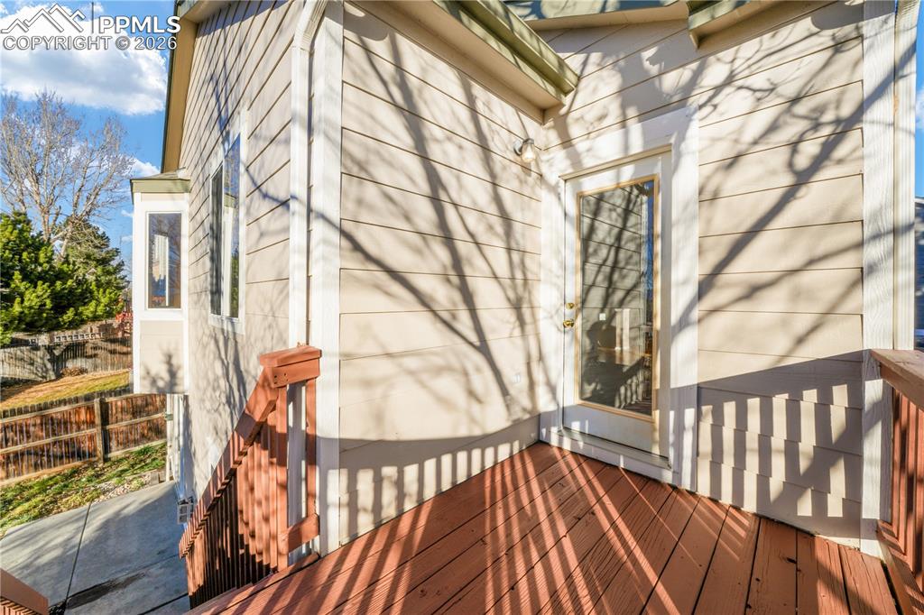 Image 14 of 50: Wood deck access from main level dining/living area with stairs to back yar