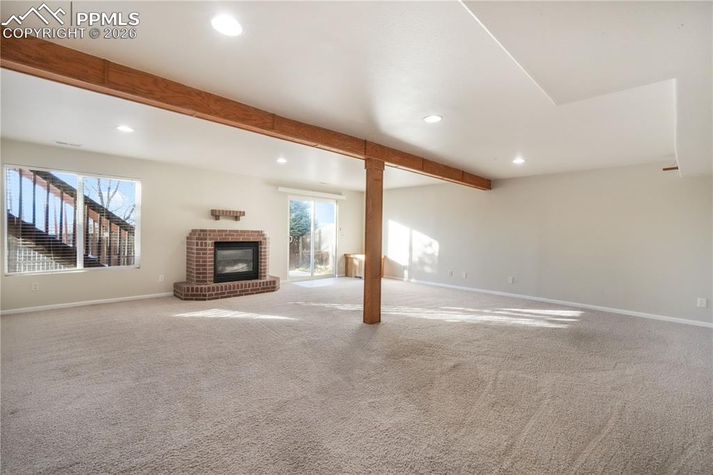 Image 30 of 50: Walk out basement family room with gas fireplace and access to back yard