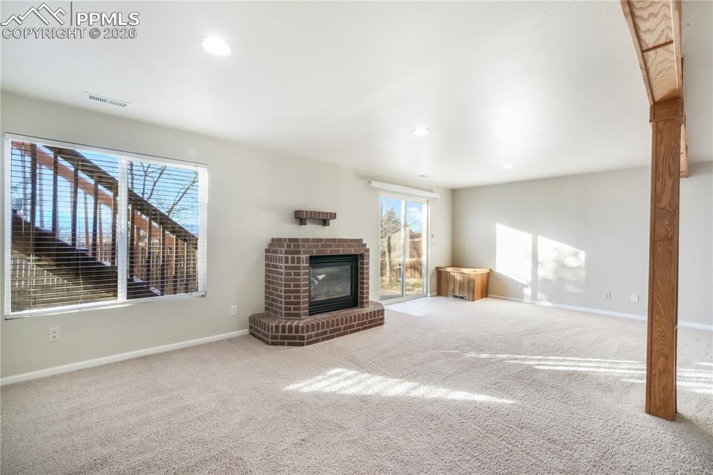 Image 31 of 50: Walk out basement family room with gas fireplace and access to back yard