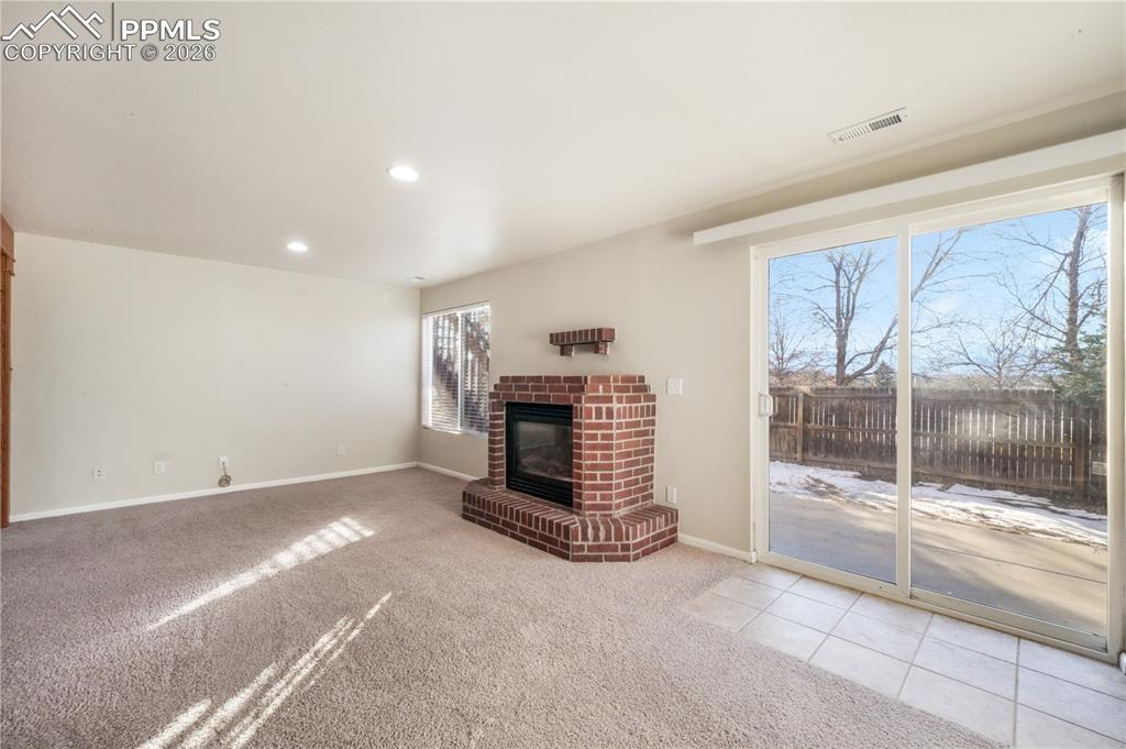 Image 32 of 50: Walk out basement family room with gas fireplace and access to back yard