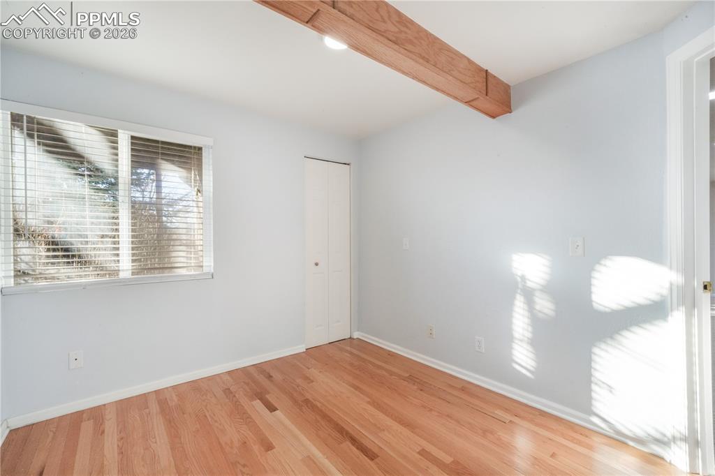 Image 36 of 50: Basement level bedroom with wood flooring