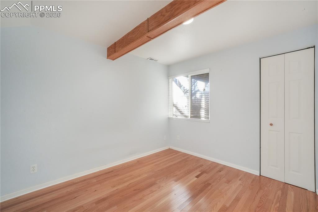 Image 37 of 50: Basement level bedroom with wood flooring