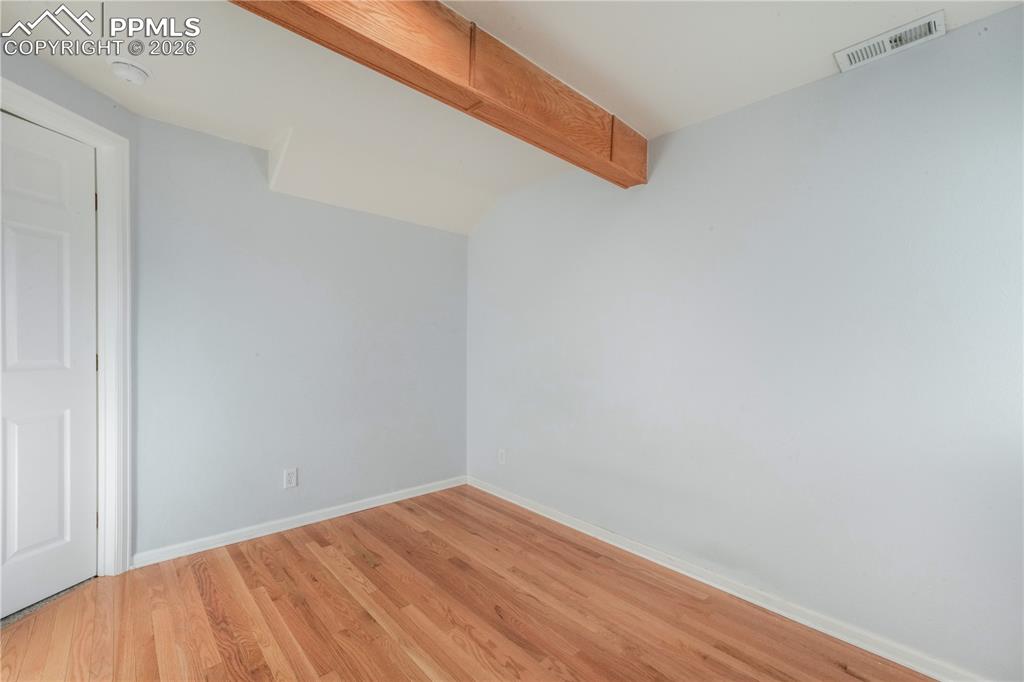 Image 38 of 50: Basement level bedroom with wood flooring