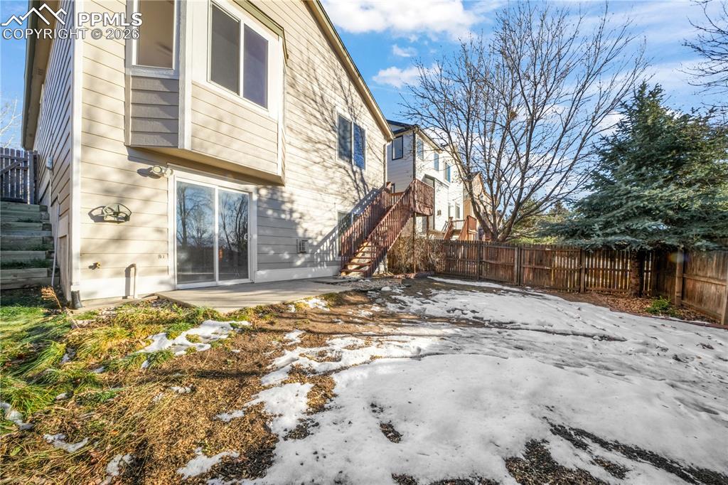 Image 43 of 50: Walk out basement from family room, large yard with privacy wood fence and 