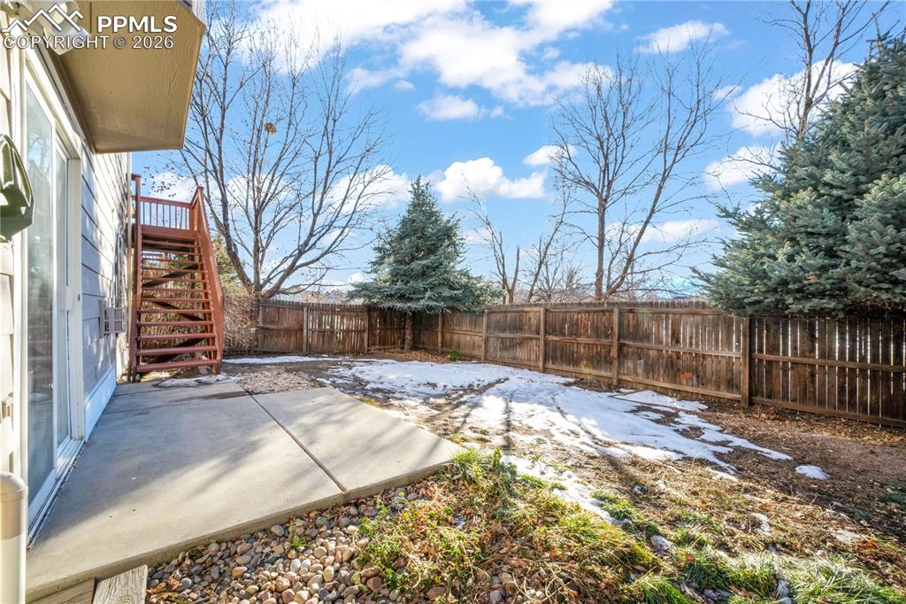 Image 44 of 50: Walk out basement from family room, large yard with privacy wood fence and 