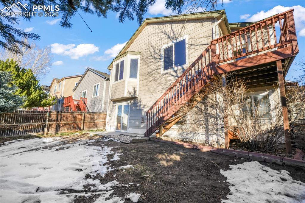 Image 45 of 50: Walk out basement from family room, large yard with privacy wood fence and 