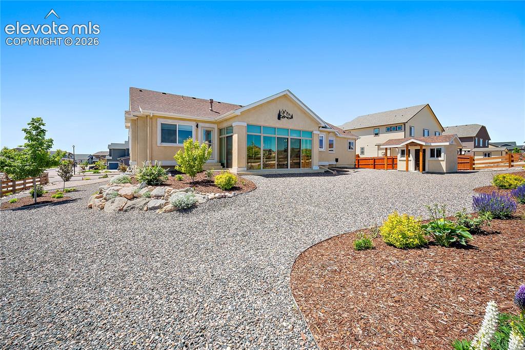 Image 33 of 44: Back of the home, beautiful and well maintained landscaping. 