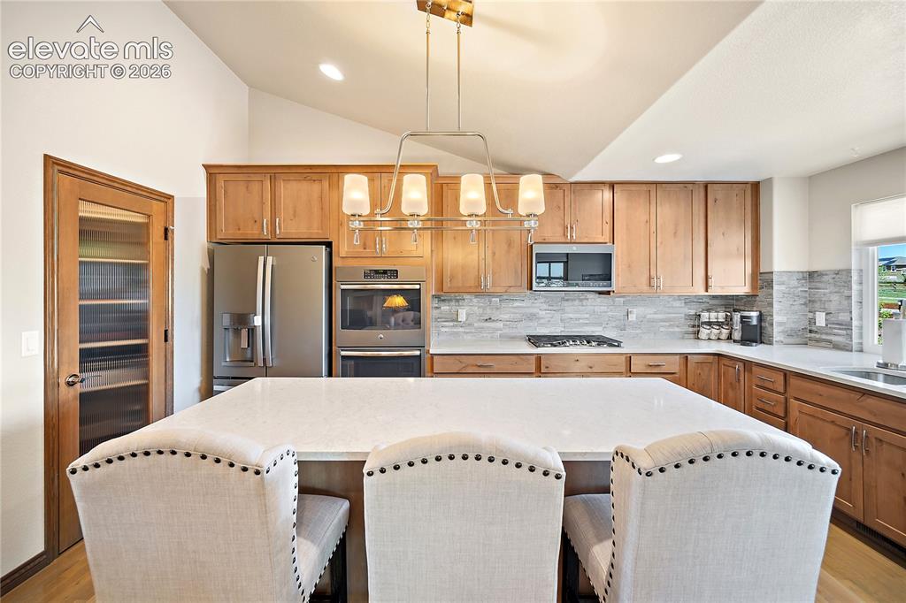 Image 9 of 44: Gourmet kitchen with double oven, gas range, quartz, walk-in pantry and vau