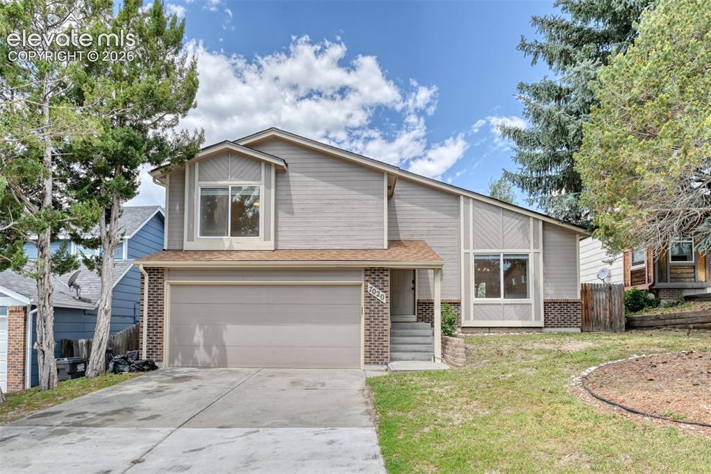 Image 1 of 50: 4 level residence featuring a two-car garage, brick accents, and a shingle