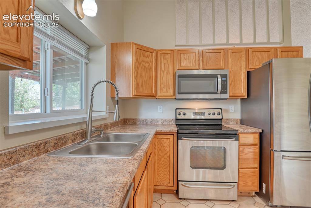 Image 11 of 50: Kitchen featuring stainless steel appliances, light wood-finish cabinetry,