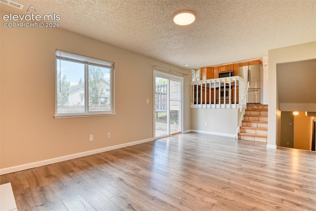 Image 16 of 50: Open-concept living area featuring wood-finish flooring, a sliding glass do