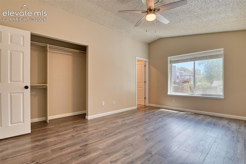 Image 19 of 50: Spacious room featuring wood-finish flooring, neutral-toned walls, and whit
