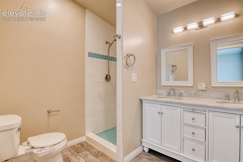 Image 23 of 50: Bathroom featuring a dual vanity with white cabinetry and a light-colored s
