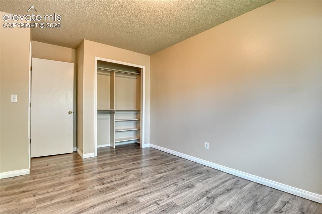 Image 26 of 50: Neutral-toned interior featuring wood-finish flooring, white baseboards, an